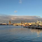 Scenic view of Cape Town harbor with boats at sunset, showcasing calm waters and serene sky.